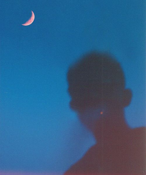 Elegant silhouette of a person in a yoga pose against a light blue background.